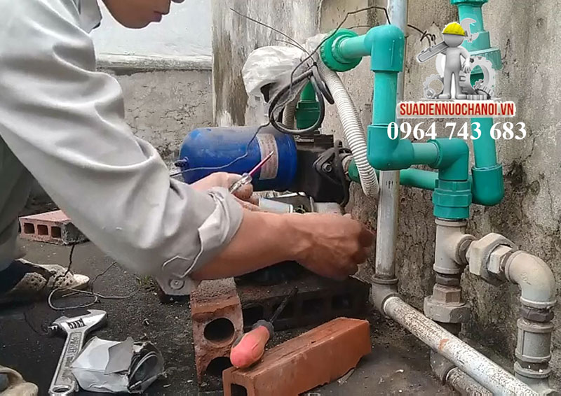 Kỹ thuật viên Bùi Đức Hùng đang sửa máy bơm nước tại quận Hà Đông